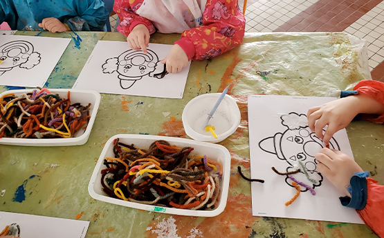 mains enfants qui collent de la laine sur coloriage polyèdre seynod annecy