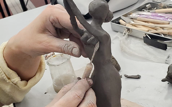 main qui sculpte une femme en poterie polyèdre seynod annecy
