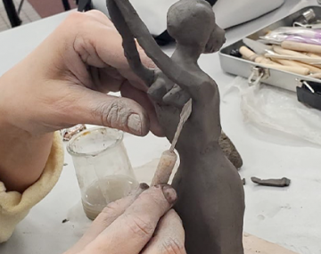 main qui sculpte une femme en poterie polyèdre seynod annecy
