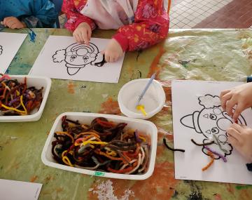 mains enfants qui collent de la laine sur coloriage polyèdre seynod annecy