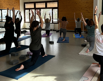 personnes sur tapis en position de yoga avec bras en l'air polyèdre seynod annecy